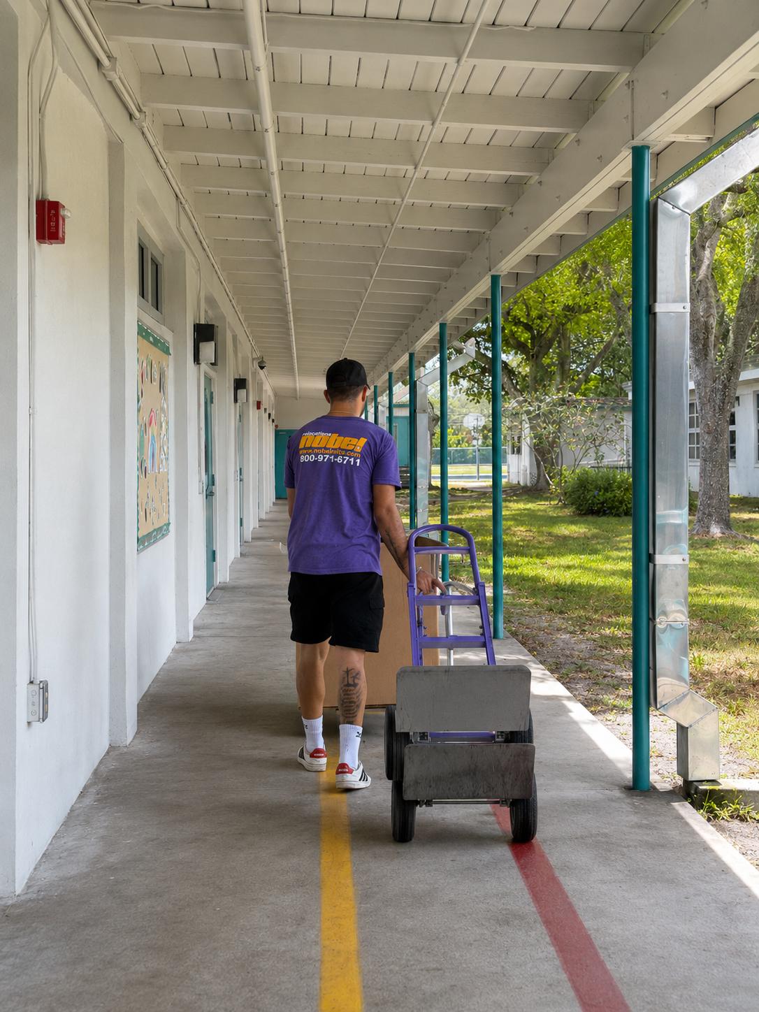 Nobel Relocation commercial mover transporting equipment through a Miami school