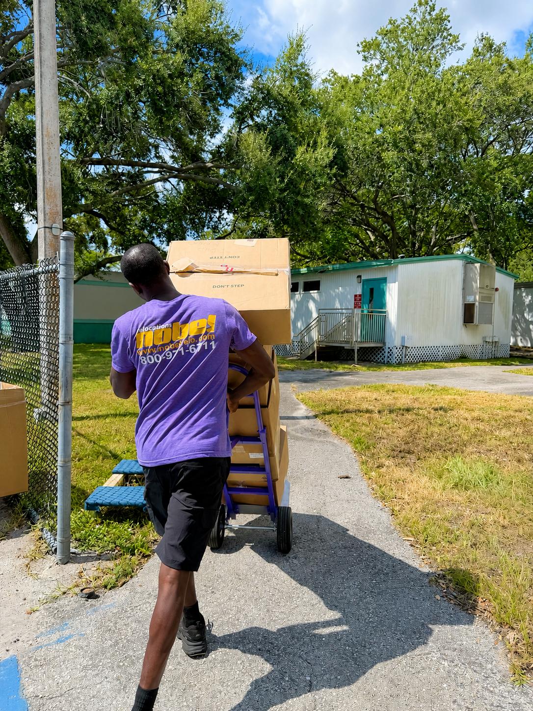 Nobel Relocation commercial movers transporting packed boxes in Miami