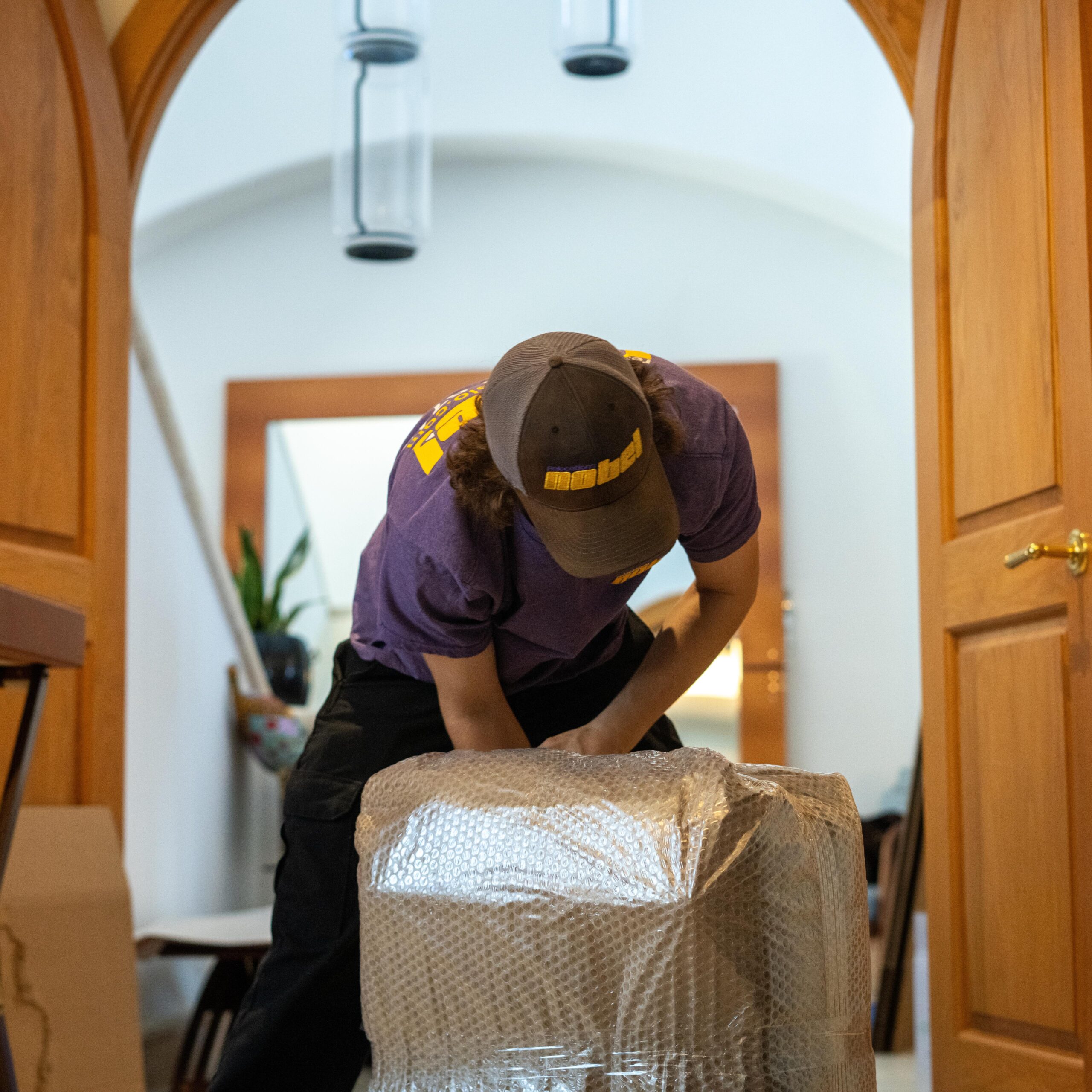Nobel Relocation professional packer protecting furniture with bubble wrap