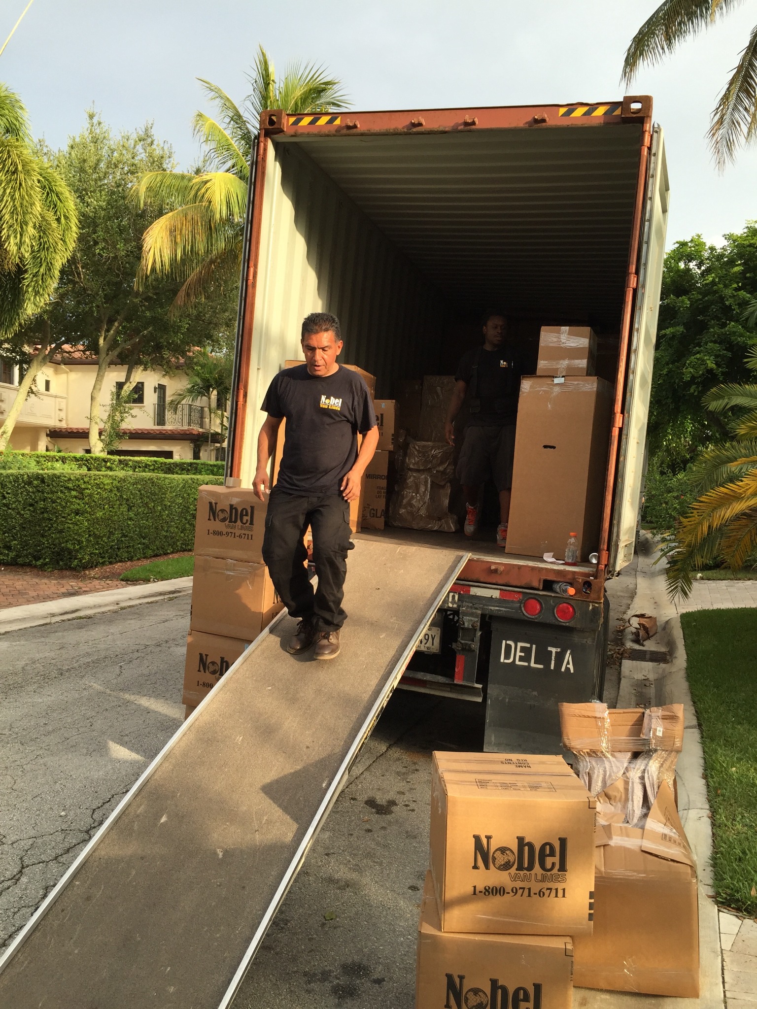Nobel Relocation team loading household goods into an international shipping container